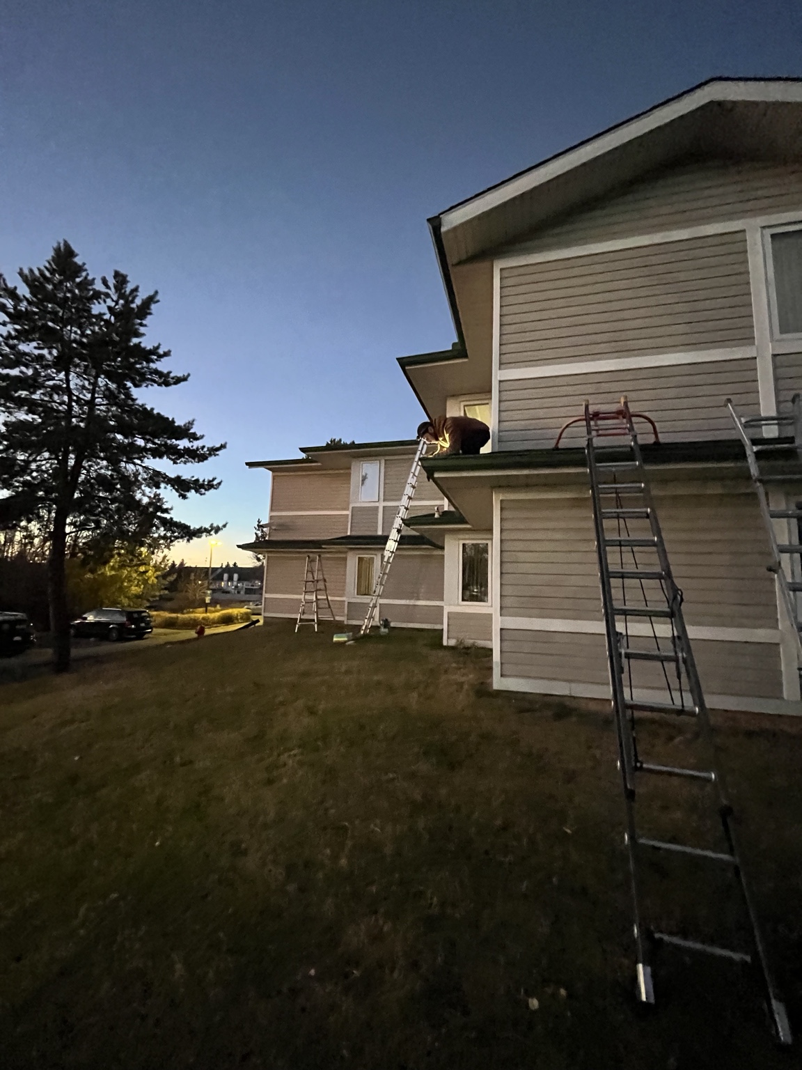 Re-Gutter crew working along the roofline of a multi-unit residential property