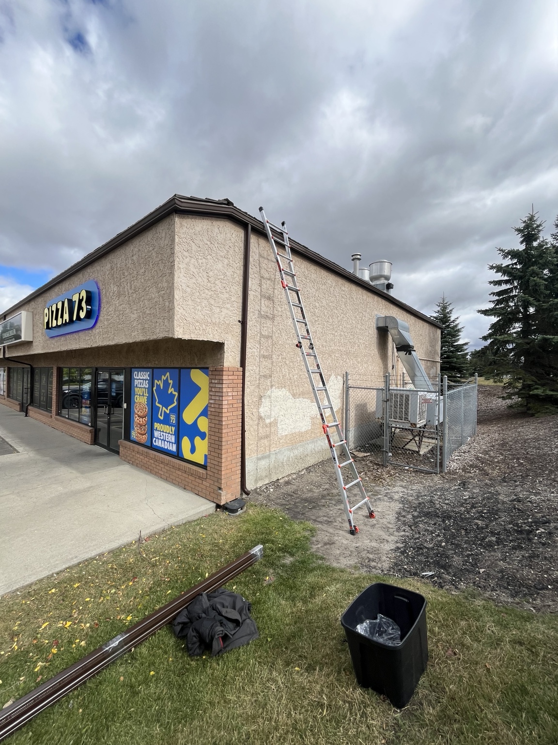 Ladder, gutter materials and downspout at a retail building job