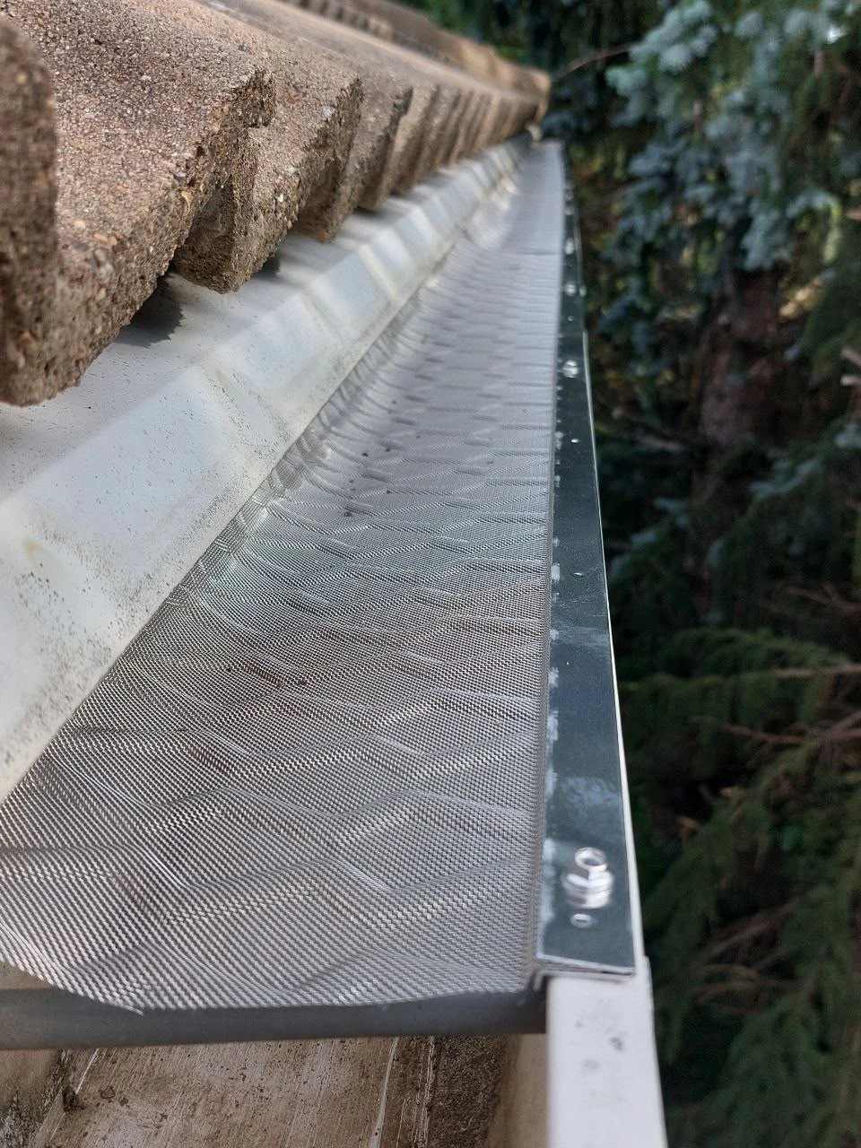 Micro-mesh leaf filter installed over a white gutter